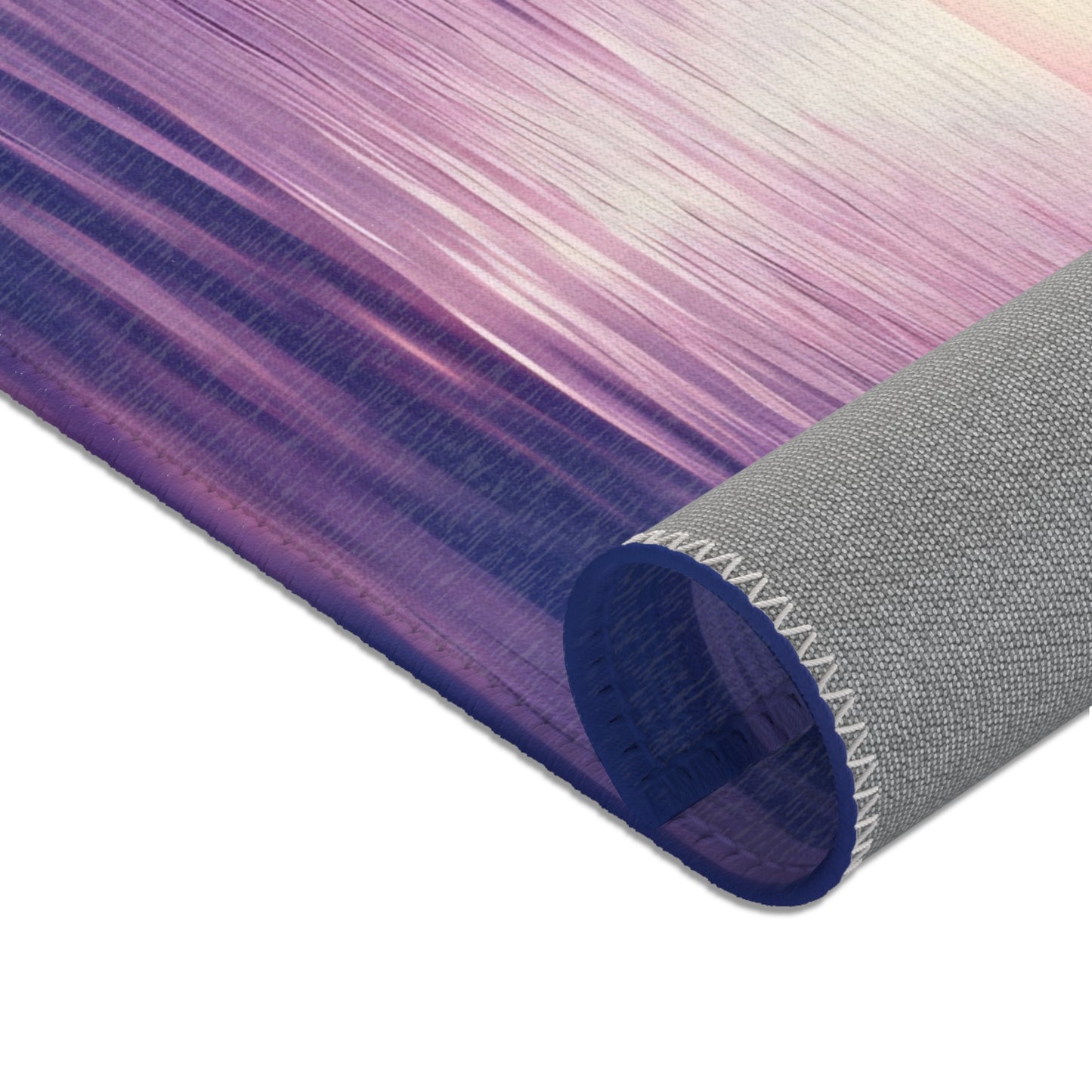 Close-up of rolled yoga mat with purple abstract design and textured non-slip backing