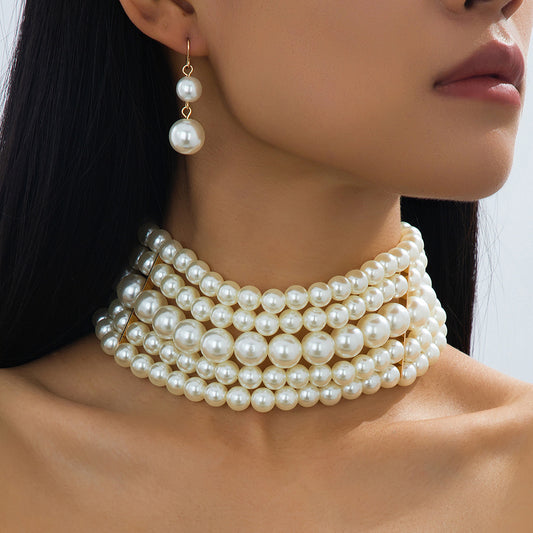 White multi-strand pearl-style choker and matching drop earrings worn together