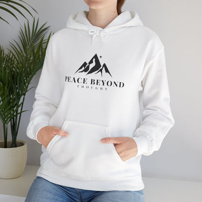 Woman wearing white hoodie with mountain graphic and 'Peace Beyond Thought' text, casual setting