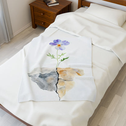 Cozy white bed with a blanket featuring a watercolor purple flower growing through cracked stone, symbolizing faith and resilience.