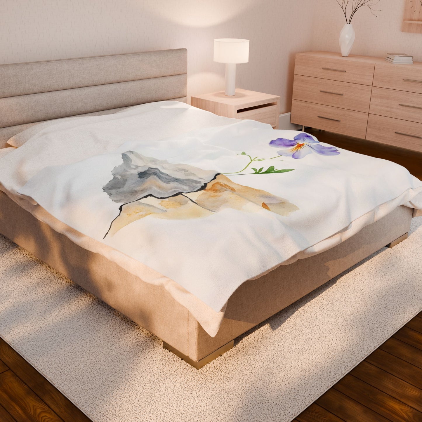 Cozy bedroom featuring a blanket with a mountain and purple flower watercolor design