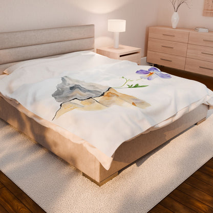 Cozy bedroom featuring a blanket with a mountain and purple flower watercolor design
