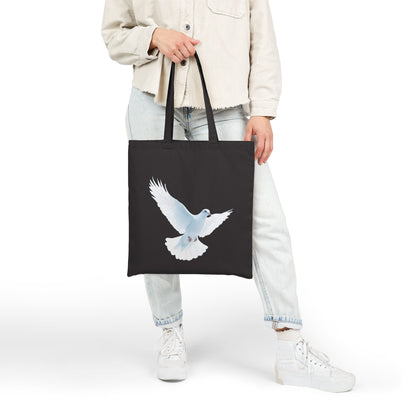 Woman holding black tote bag with white dove design, Christian faith-inspired accessory