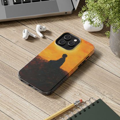 Phone case with silhouette of meditating person against orange sunset on wooden desk