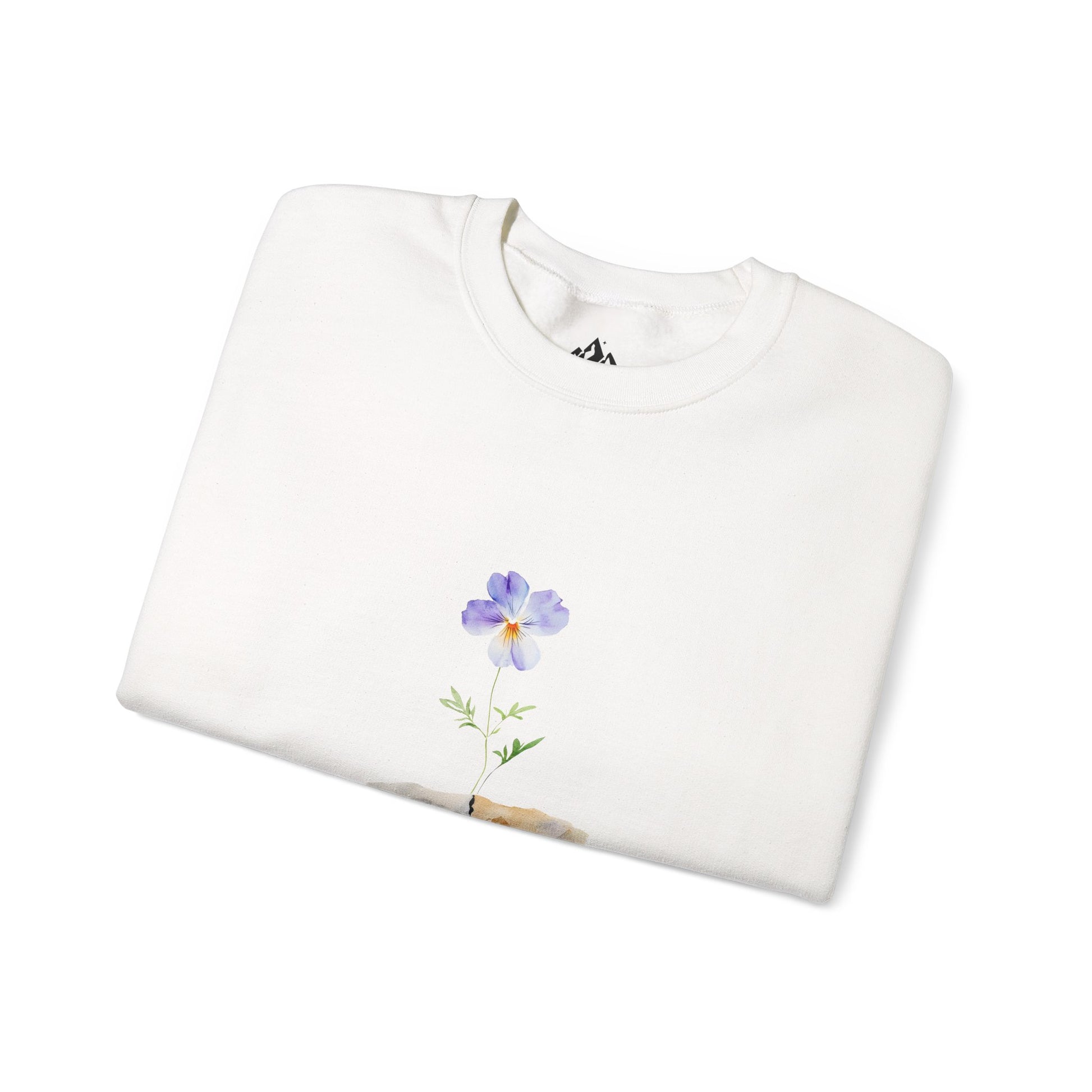 White sweatshirt with a purple flower graphic, folded on a white background