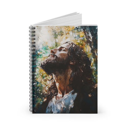 Spiral notebook with painting of contemplative bearded man looking upward in sunlit forest