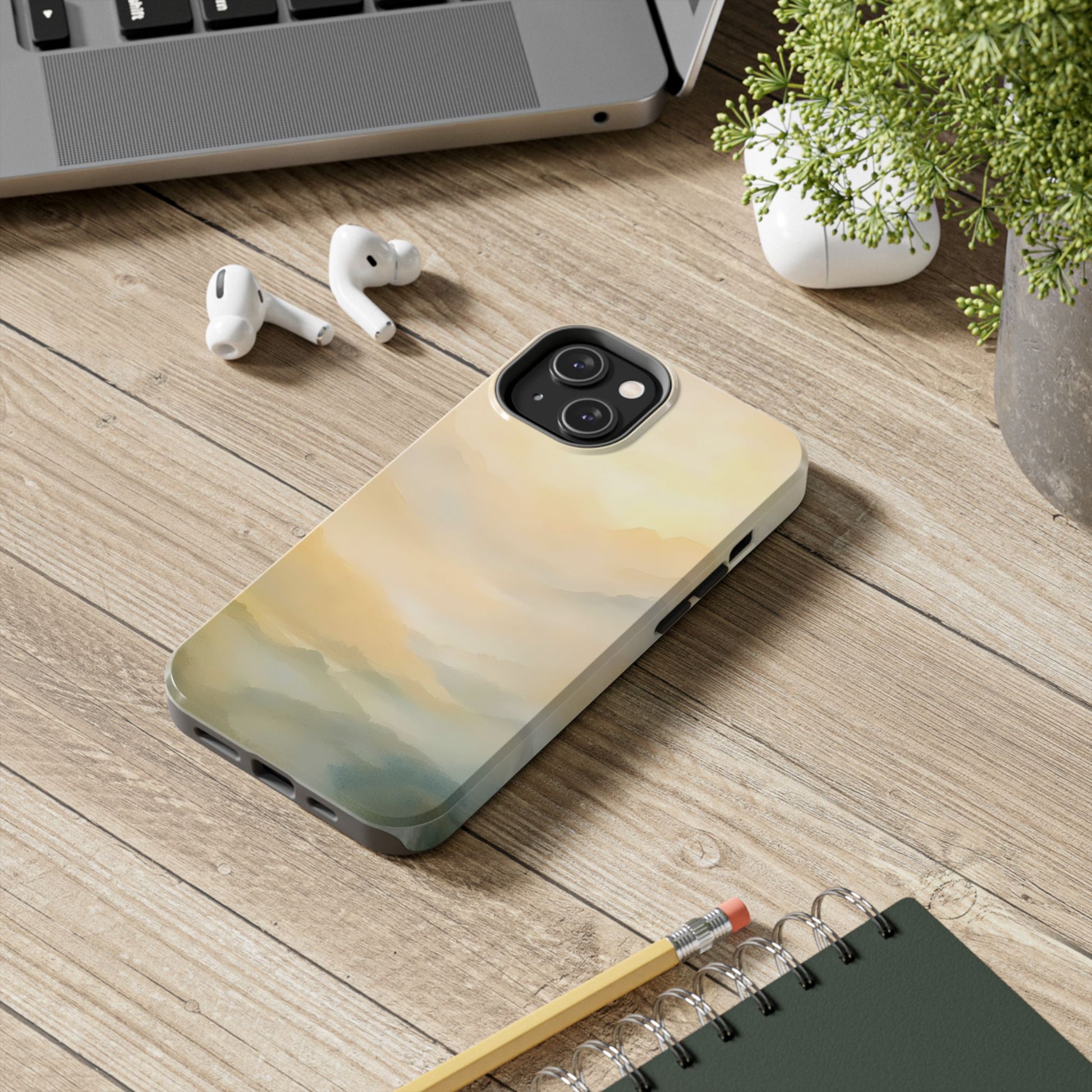 Abstract pastel cloud or landscape iPhone case on wooden desk with laptop and plant