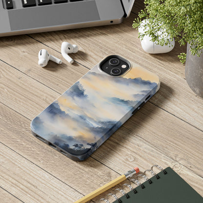 Phone case with serene watercolor mountain landscape on desk with laptop and earbuds