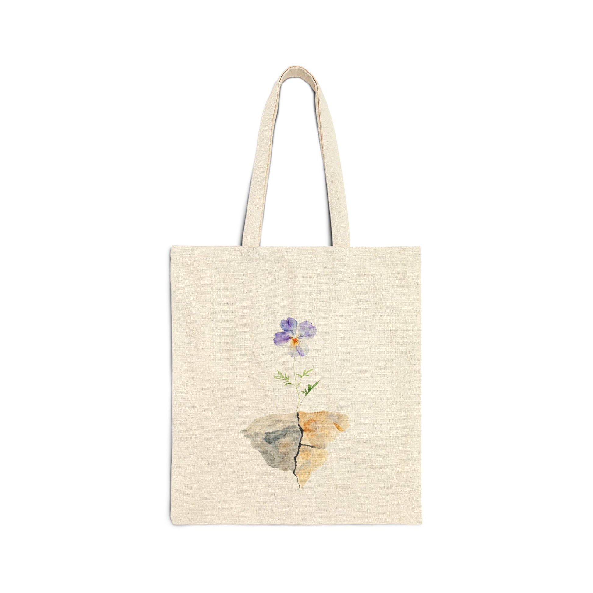 Natural cotton tote bag with a purple watercolor flower growing from cracked rocks, minimalist design
