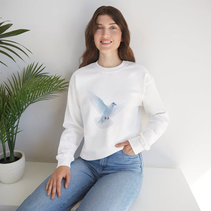 Woman in white sweatshirt with blue dove graphic, sitting indoors by a green plant