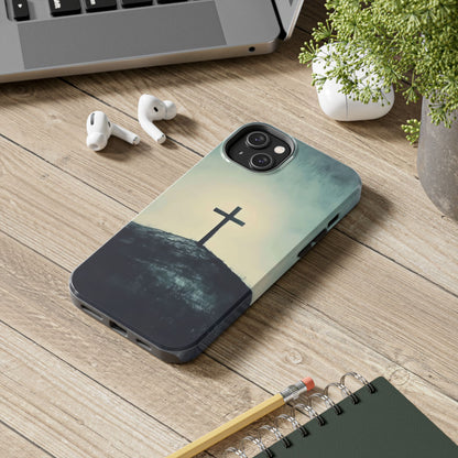 Christian cross phone case on wooden desk with laptop, AirPods, notebook, and potted plant