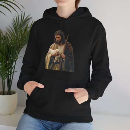 Woman wearing black hoodie with Jesus holding lamb graphic, Christian apparel, indoor setting