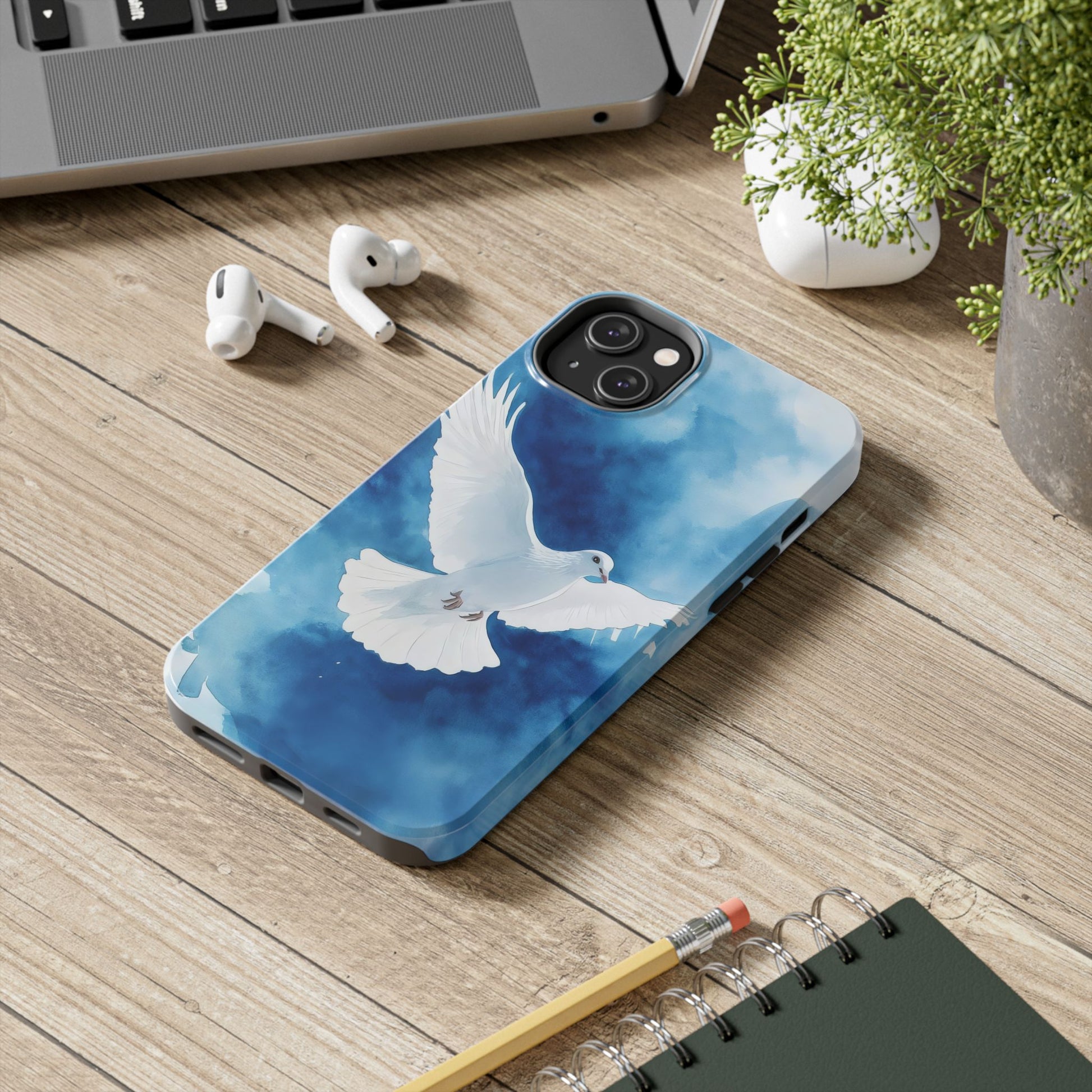 Christian phone case with white dove and blue watercolor design on wooden desk