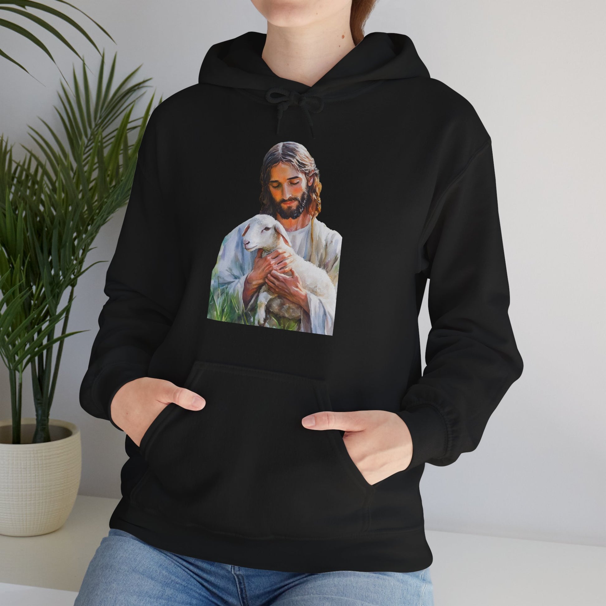 Woman wearing black hoodie with Jesus holding a lamb graphic, Christian faith apparel