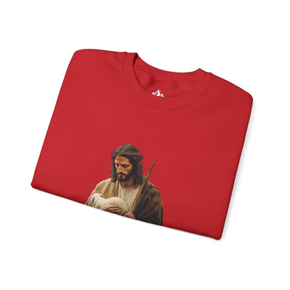 Red Christian sweatshirt with Jesus holding a lamb, faith-inspired apparel flat lay