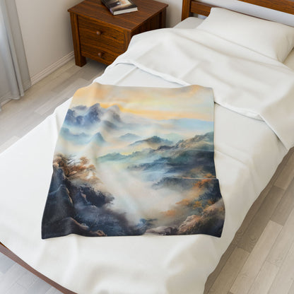 Soft throw blanket with serene mountain landscape art draped on a white bed