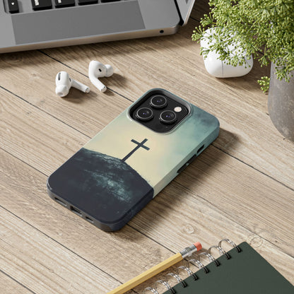 Christian cross phone case on wooden desk with earbuds, laptop, and plant