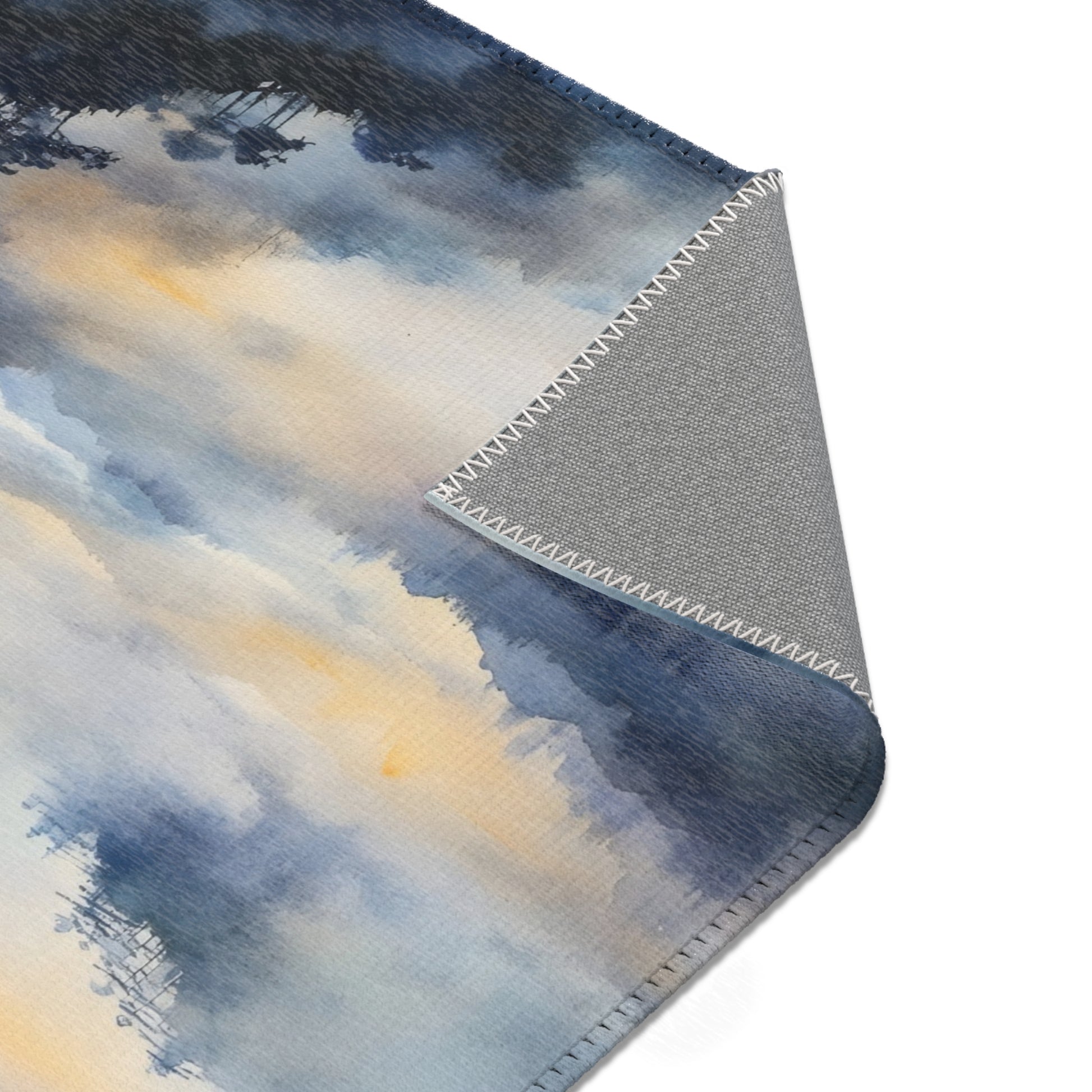 Watercolor landscape throw blanket with blue, gray, and soft yellow tones, close-up view
