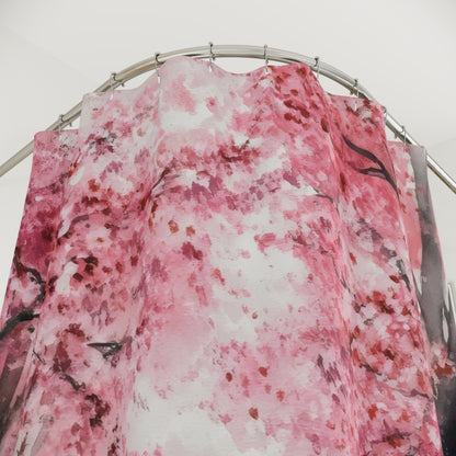 Pink cherry blossom floral shower curtain hanging on a curved rod in a bright bathroom