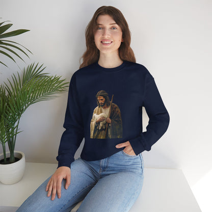 Woman in a navy Christian sweatshirt with shepherd and lamb graphic, seated by indoor plant