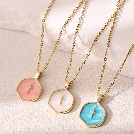 Pink, cream and blue round cross pendants displayed together