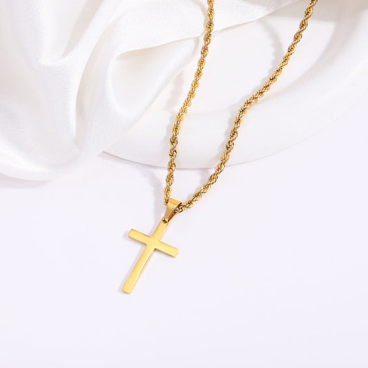 Gold-tone cross necklace on pale fabric