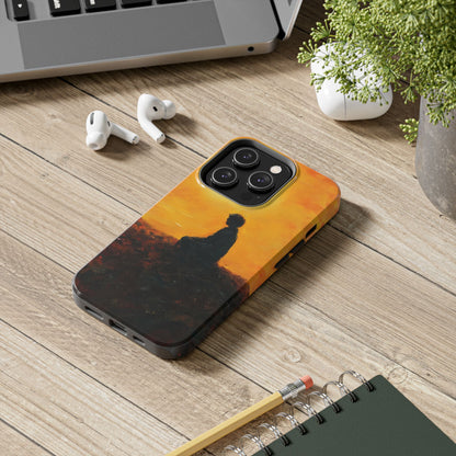 Phone case with meditative silhouette against orange sunset, on wooden desk with earbuds and laptop
