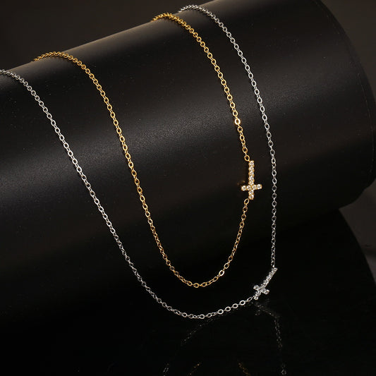 Gold-tone and silver-tone mini cross necklaces on a dark display