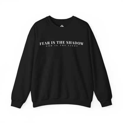 Black Christian sweatshirt with 'Fear is the shadow, God is the light' faith-inspired text.