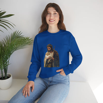 Woman wearing blue Christian sweatshirt with shepherd and lamb graphic, sitting indoors by plant