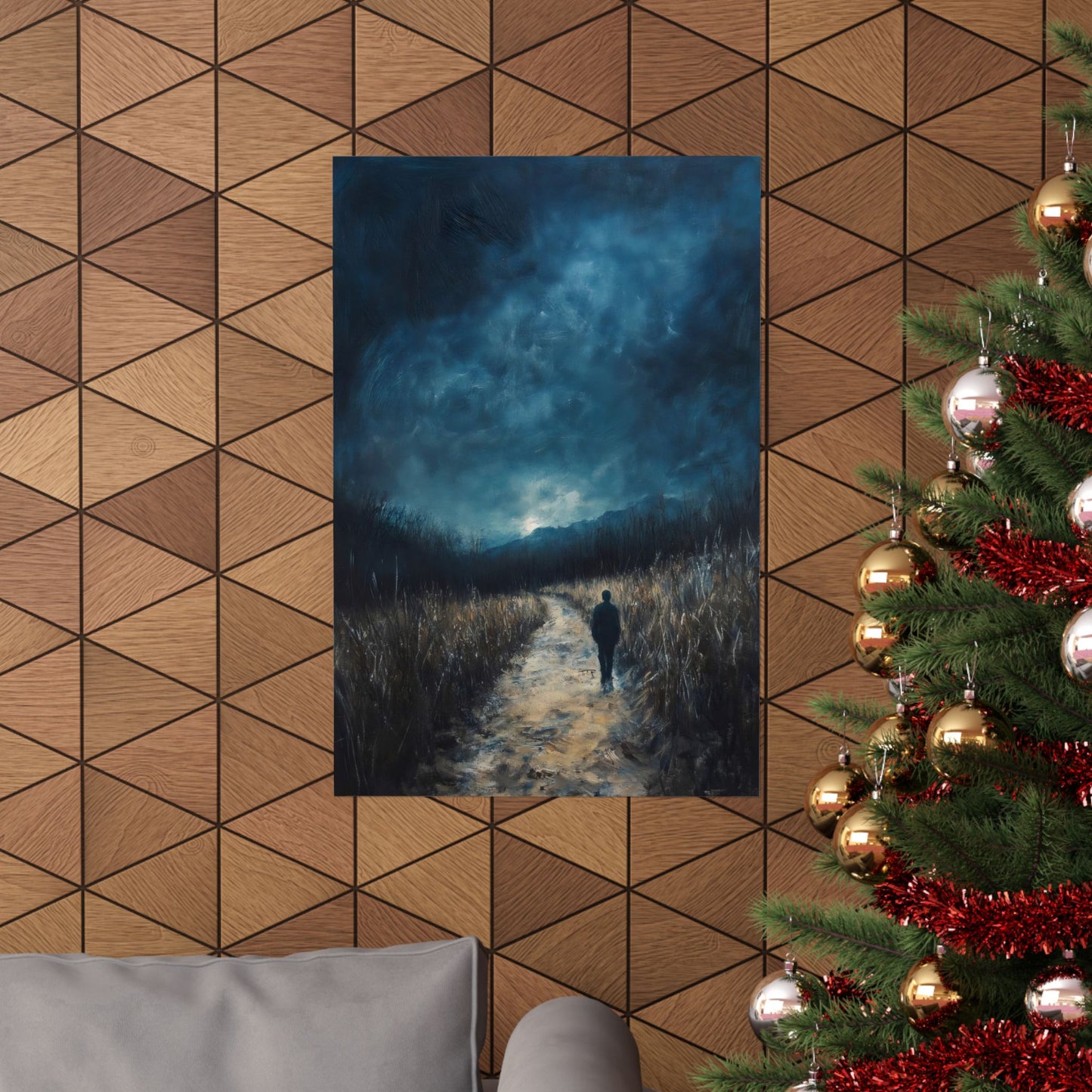 Christian wall art of person walking on path at dusk, displayed above sofa near Christmas tree.
