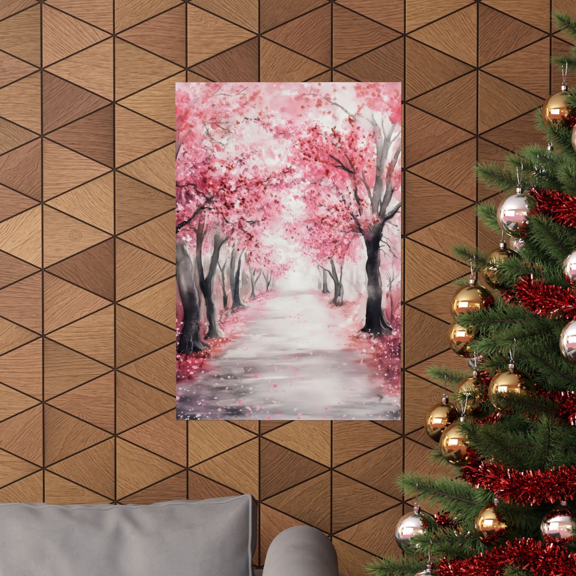 Framed cherry blossom wall art above a modern sofa, Christmas tree with gold ornaments nearby