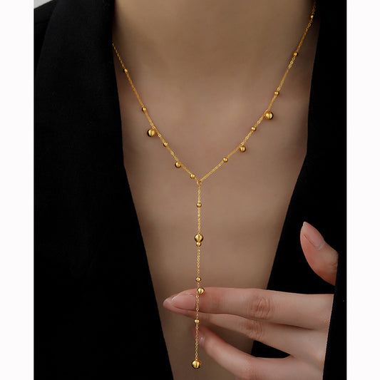 Long Y-shaped tassel necklace worn at the collarbone