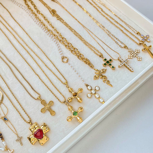 Gold-tone cross necklaces displayed together on a jewelry tray